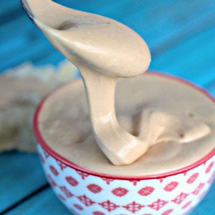 a spoon full of peanut butter sitting in a bowl