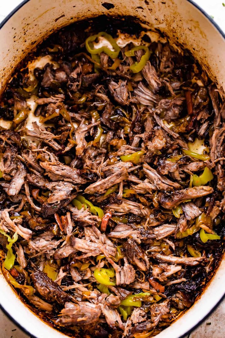 a large pot filled with meat and peppers