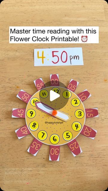 a clock with numbers on it sitting on top of a wooden table next to a sign that says, master time reading with this flower clock printable