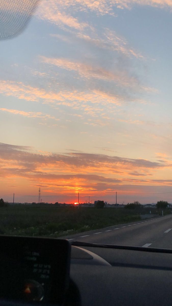 the sun is setting over an empty highway