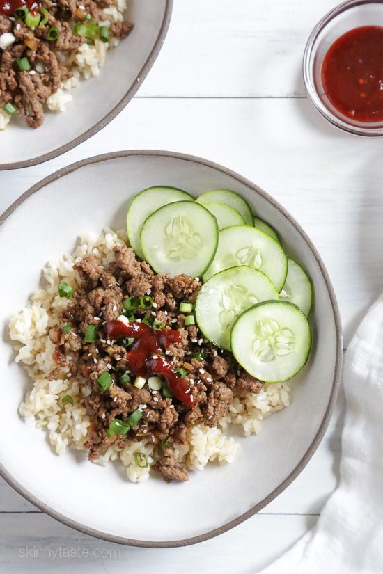 two plates filled with rice, cucumbers and meat