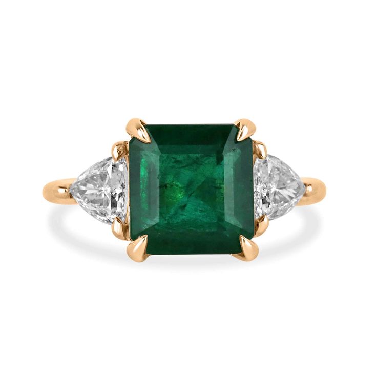 an emerald and diamond ring, with three diamonds on each side in yellow gold plated silver