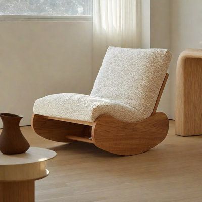 a living room with a rocking chair and coffee table next to it on top of hard wood flooring