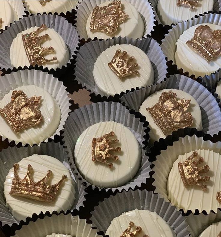 cupcakes decorated with gold and white frosting are arranged in the shape of crowns