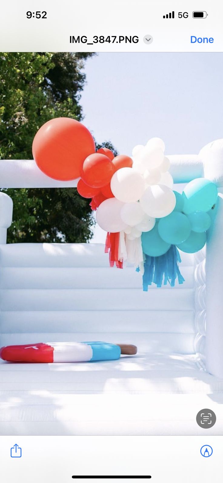 an inflatable arch decorated with balloons and tassels is shown on the phone