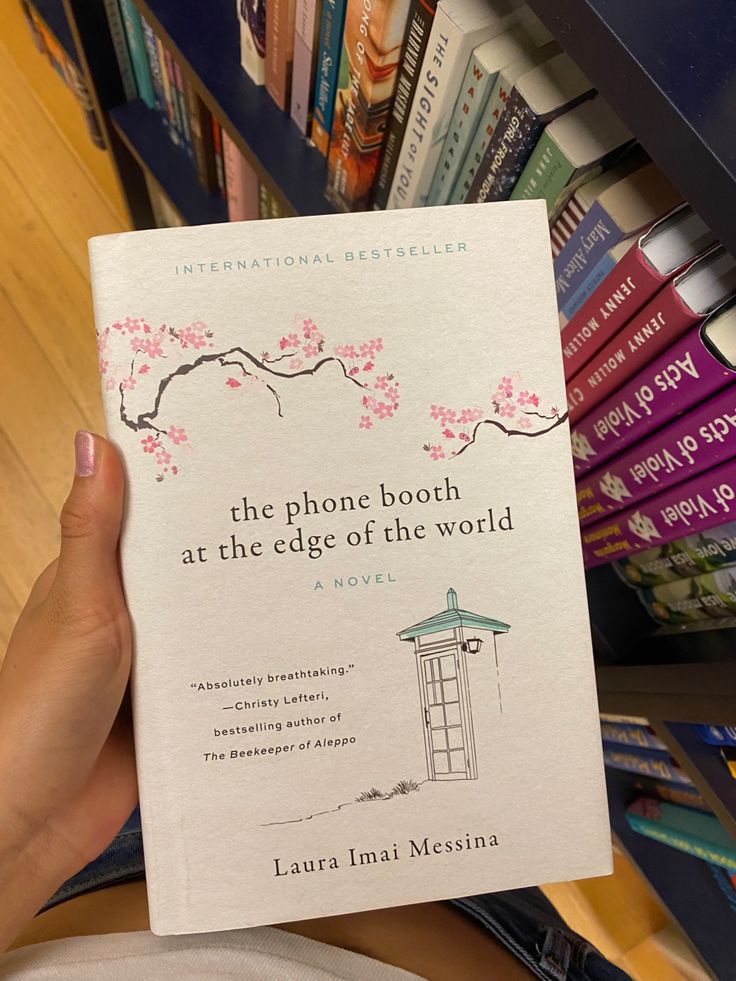 the phone booth at the edge of the world is in front of bookshelves