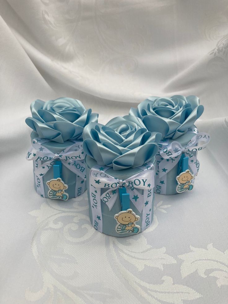 three small blue roses are sitting on a white table cloth with the words joy in it