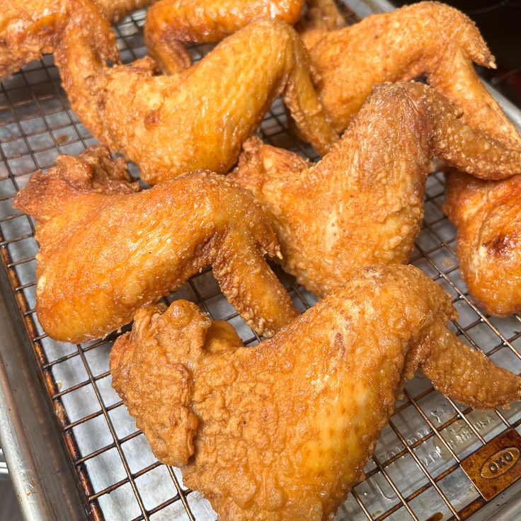 fried chicken wings cooling on a metal rack