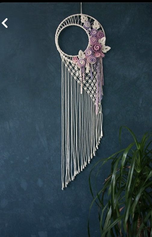 a macrame hanging on the wall with flowers