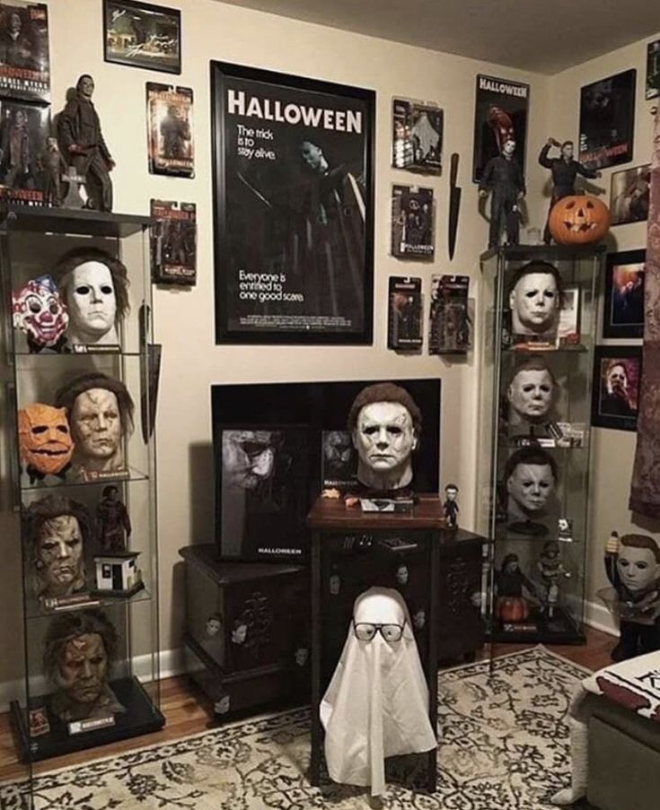 a living room filled with halloween decorations and masks on the wall above a tv set