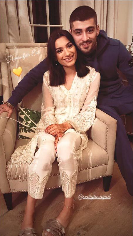 a man and woman sitting on top of a chair