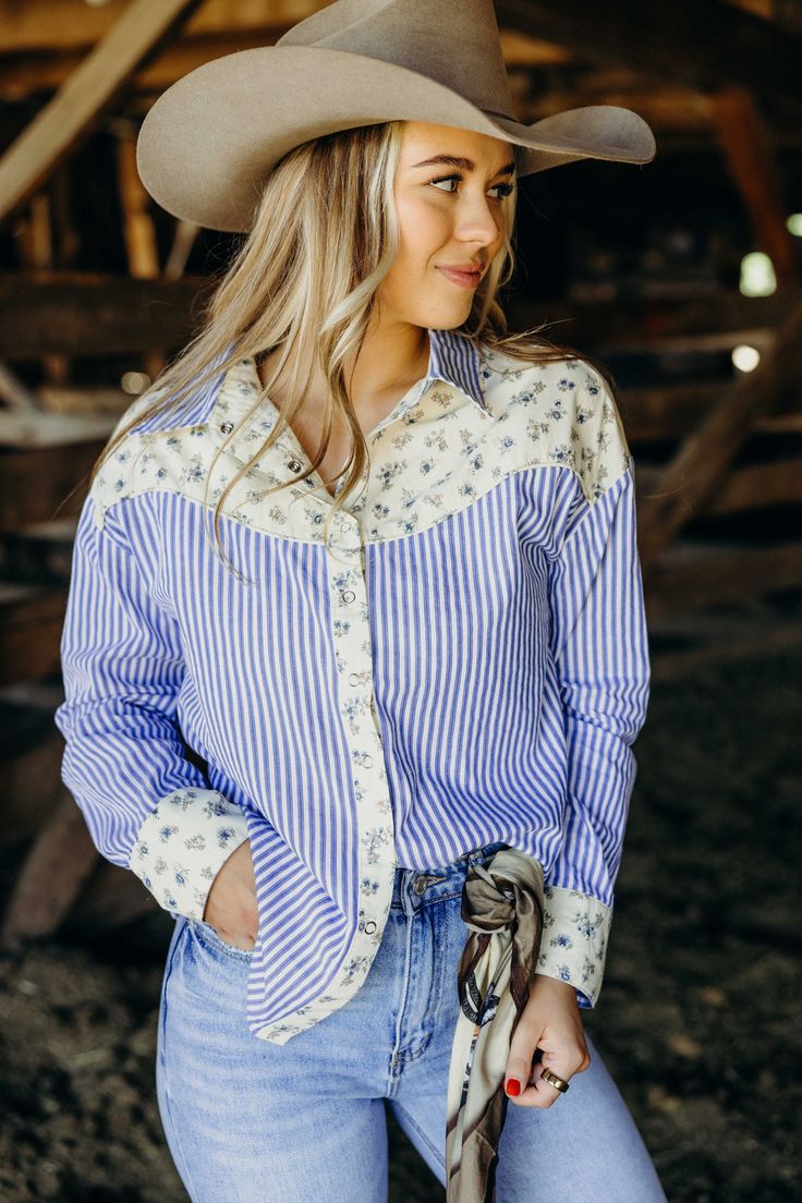 Yeehaw to the cutest cowgirl shirt in town! The Dollie Shirt features a playful mix of floral print and stripes, perfect for bringing some fall flair to your western style. With a classic button down design in a beautiful blue color, you'll want to wrangle this top into your wardrobe ASAP. Courtney is wearing size small paired with The Derek Jeans, The Adaire Mules, Felt Cowboy ProHat and Cattle Guard Wild Rag Cattle Guard, Western Cotton Button-up Tops, Western Blue Button-up Top, Blue Button-up Shirt For Ranch, Cowgirl Plaid Shirt, Western Style Button-up Ranch Shirt, Cowgirl Shirts, Wild Rag, Curvy Dress