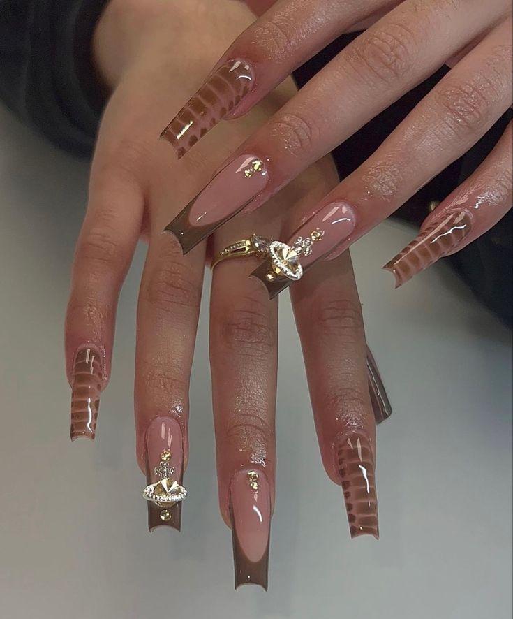 a woman's nails with gold decorations on them and some rings in the middle