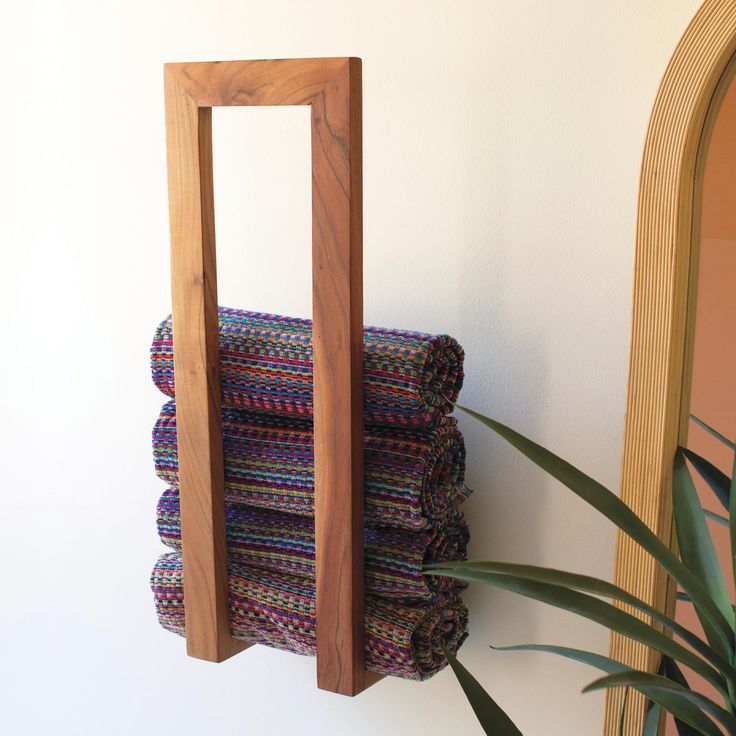 a stack of folded towels sitting on top of a wooden rack