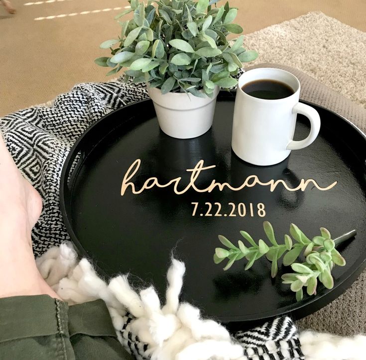 a black tray with the names of two people and a potted plant on it