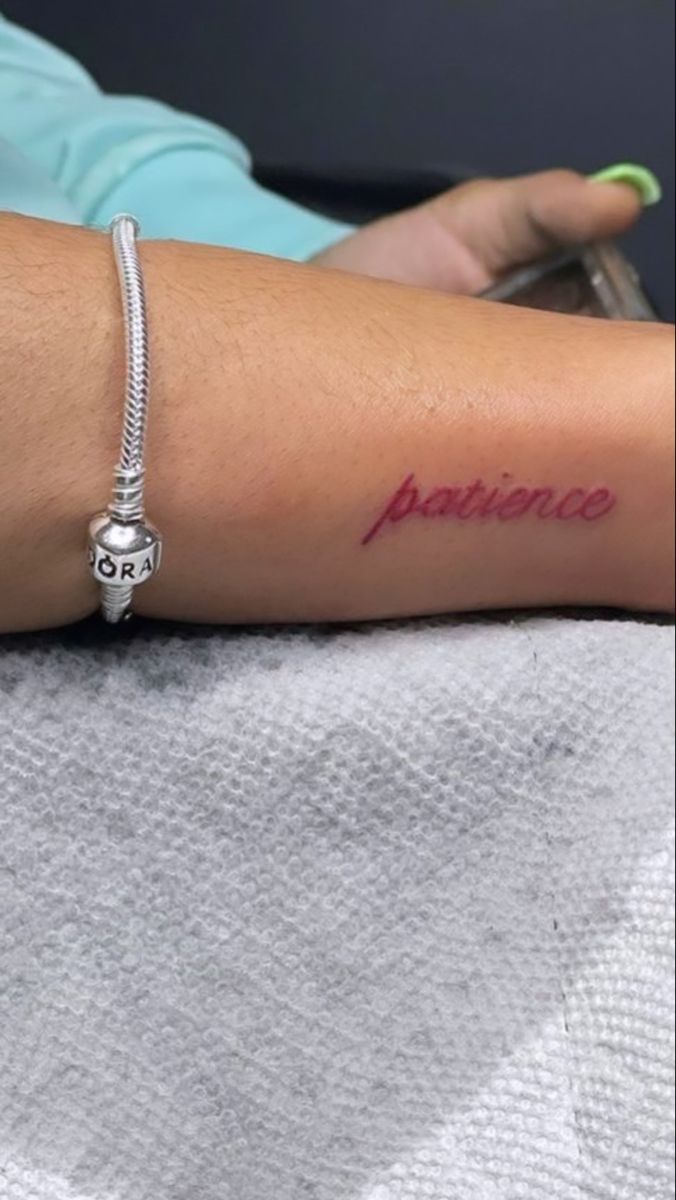 a woman with a tattoo on her arm that reads, happiness and is sitting in a chair