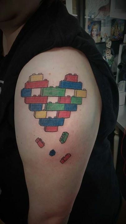 a heart made out of legos on the back of a woman's shoulder