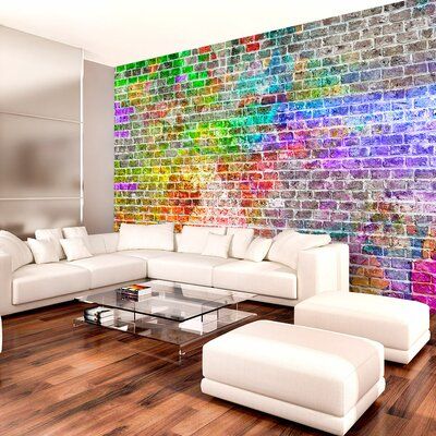 a living room filled with white furniture next to a wall covered in colorful brick tiles