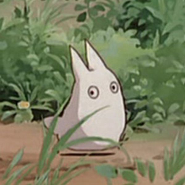 a cartoon character sitting in the grass with his eyes wide open and one eye half closed