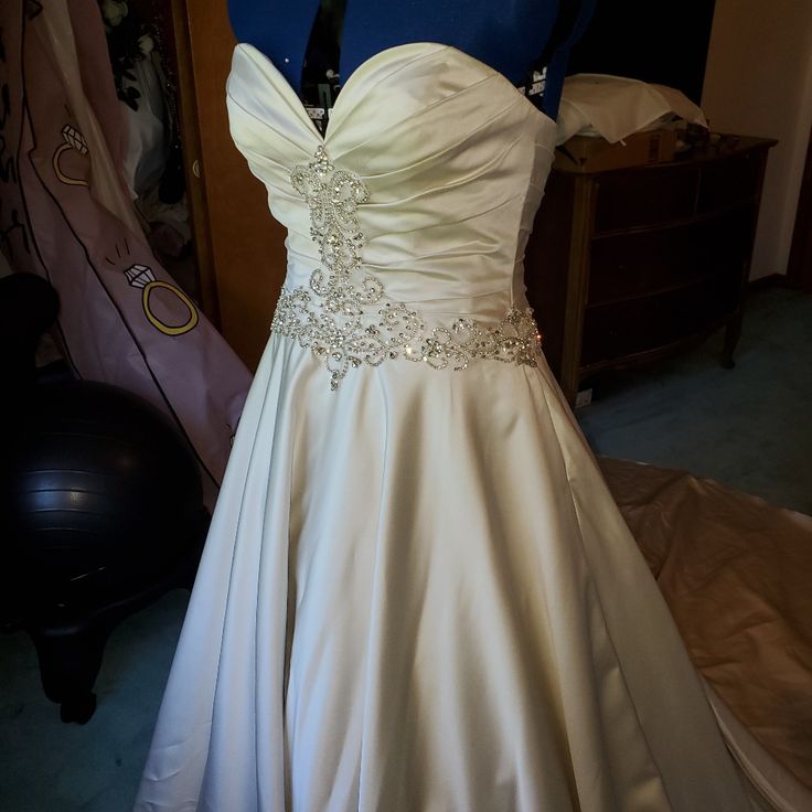 a wedding dress is displayed on a mannequin