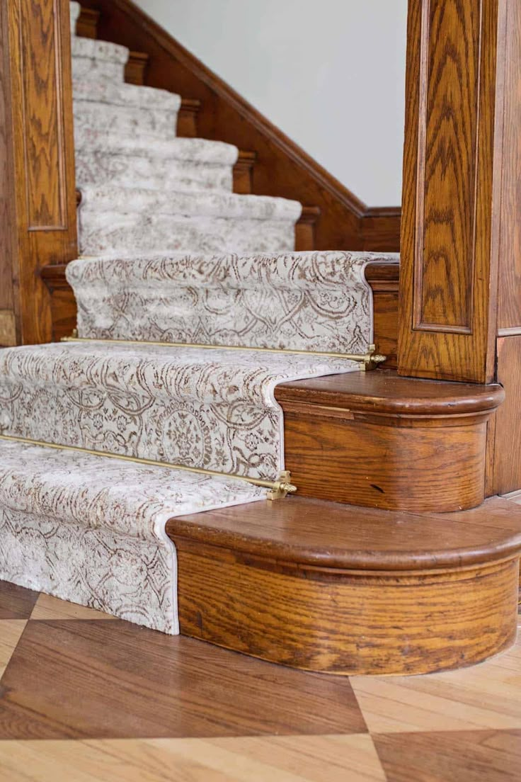 a wooden staircase with white carpet and wood handrails