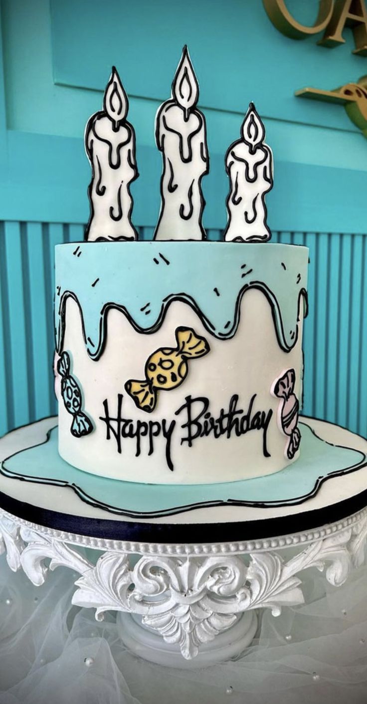 a blue and white birthday cake with lit candles