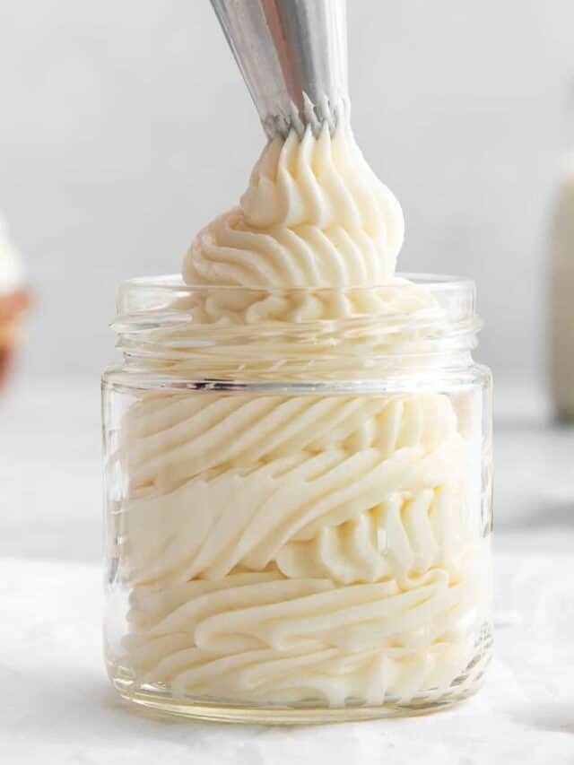 a glass jar filled with whipped cream and a spoon sticking out of the top one