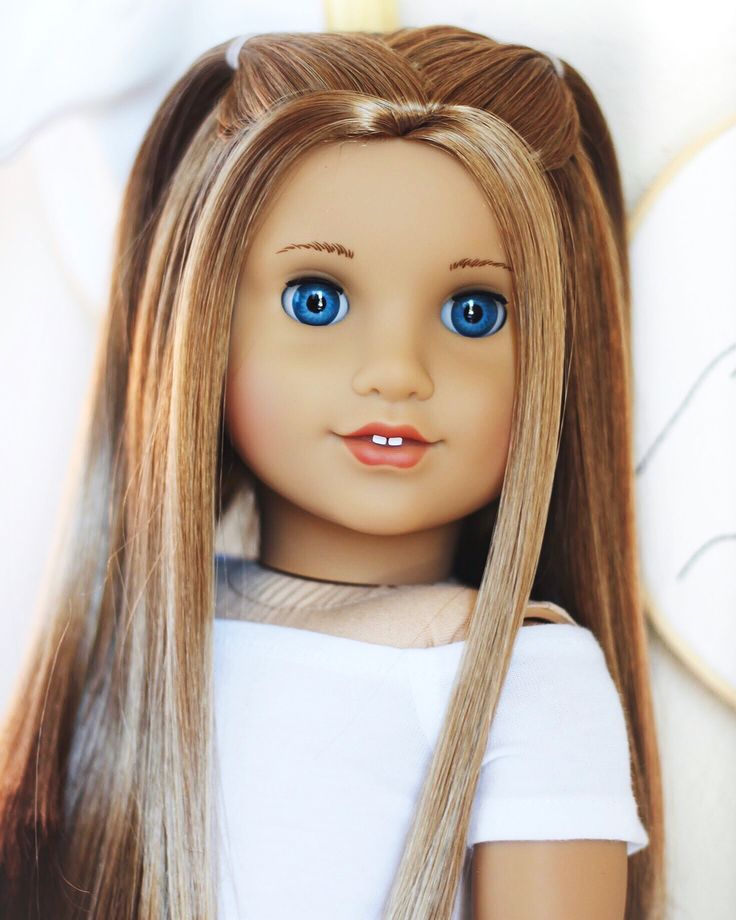 a doll with long blonde hair wearing a white t - shirt and blue eyeliners