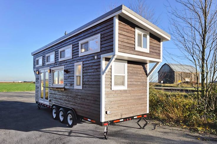 a tiny house on wheels parked in a parking lot