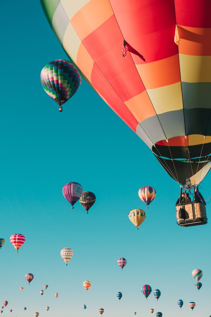 many colorful hot air balloons flying in the sky