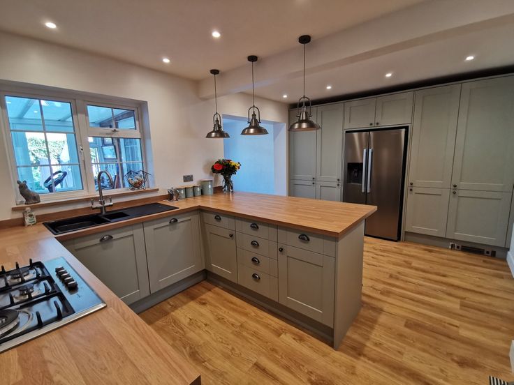 a kitchen with wooden floors and gray cabinets