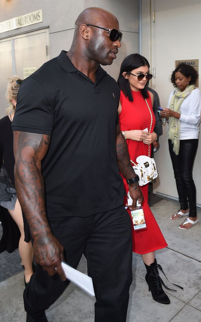 a man in black shirt and red dress standing next to a woman with sunglasses on