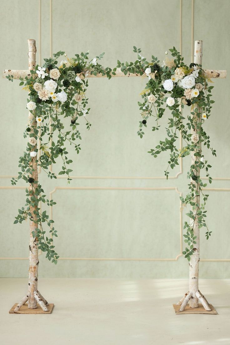 two wooden crosses decorated with flowers and greenery