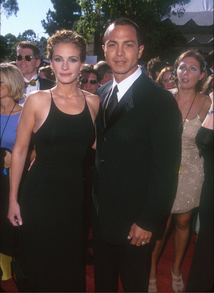 a man and woman standing next to each other on a red carpet at an event