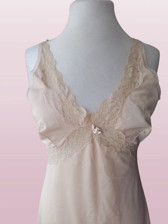 Vintage 70s lingerie, nylon nightgown , new oldstok , beige under dress , retro lace , slip dress S-M ,newer worn Bust: 92 cm / 36 in Waist: 80 cm/ 31 in Hips: 110 cm/ 43 in Lenght:  100 cm/ 39 in Size : S-M Materials: 100% nylon Condition: perfect vintage condition Defects: none See more like this in my shop: https://www.etsy.com/shop/VintageInsparation?ref=seller-platform-mcnav Lace Slip Dress With Built-in Bra For Daywear, Feminine Camisole Slip Dress With Delicate Lace, Feminine Sleeveless Slip Dress With Lace Bodice, Sheer Camisole Slip Dress For Daywear, Feminine Cream Slip Dress With Spaghetti Straps, Lace Camisole Slip Dress With Lace Bodice, Sleeveless Lace Slip Dress With Built-in Bra, Coquette Lace Trim Slip Dress For Daywear, Flirty Lace Trim Slip Dress For Daywear