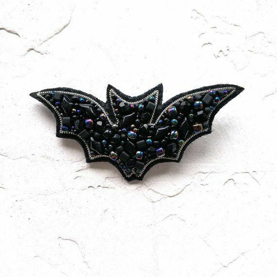 a bat shaped brooch sitting on top of a white surface