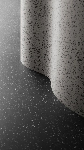 a black and white photo of a wall with speckles on the surface,