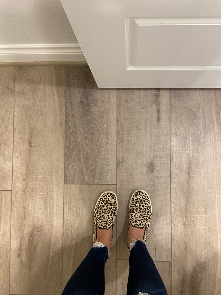 a person standing on top of a wooden floor next to a white ceiling mounted light