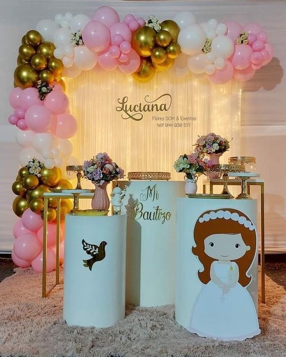 a table topped with two vases filled with pink and white flowers next to balloons