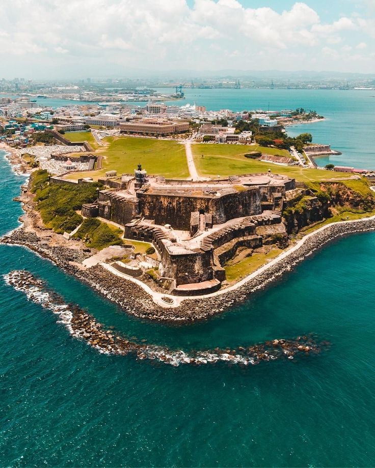 an island in the middle of the ocean surrounded by land and water with buildings on it