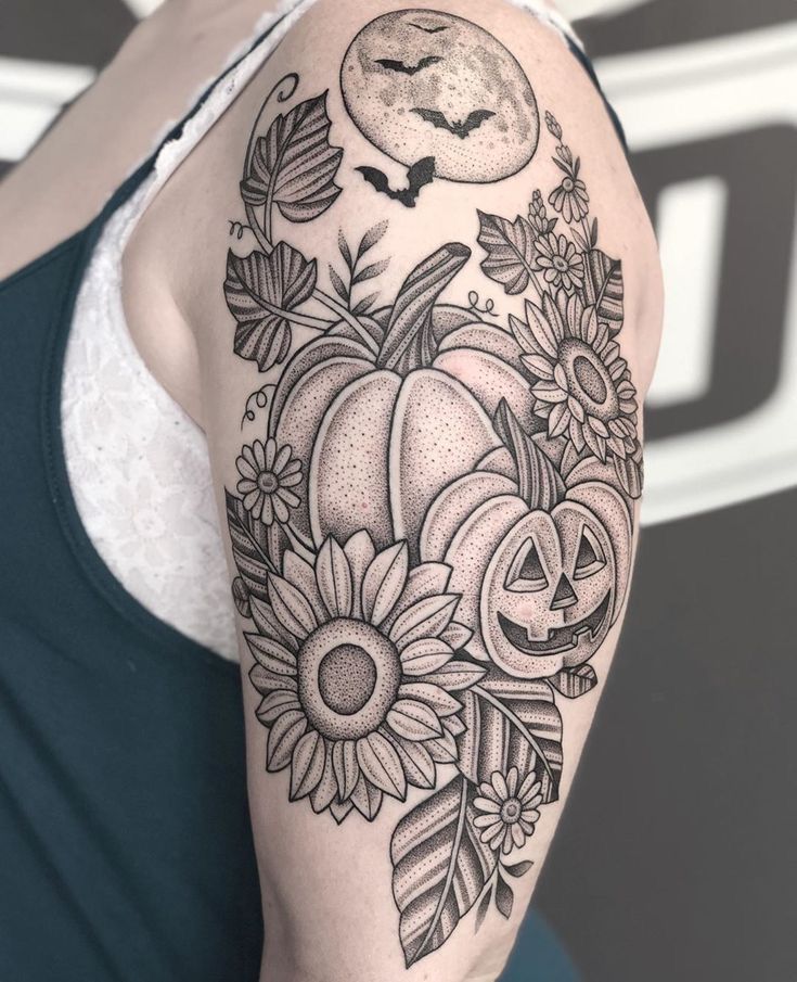 a woman's arm with flowers and pumpkins in the middle, on her left shoulder