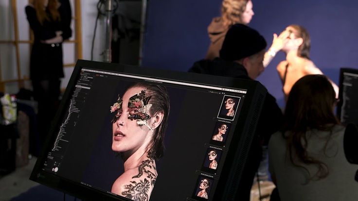 a woman is getting her makeup done in front of the camera while others look on