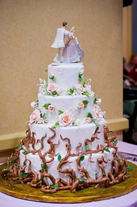 a wedding cake is decorated with flowers and vines