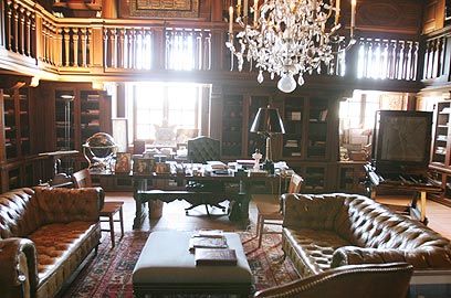 a living room filled with lots of furniture and a chandelier hanging from the ceiling