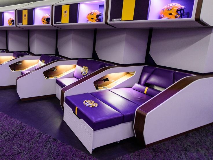 purple and white seats are lined up in the middle of an airport lounge area with shelves on either side