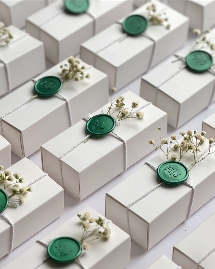 many white boxes with green buttons and small flowers on them are lined up in rows