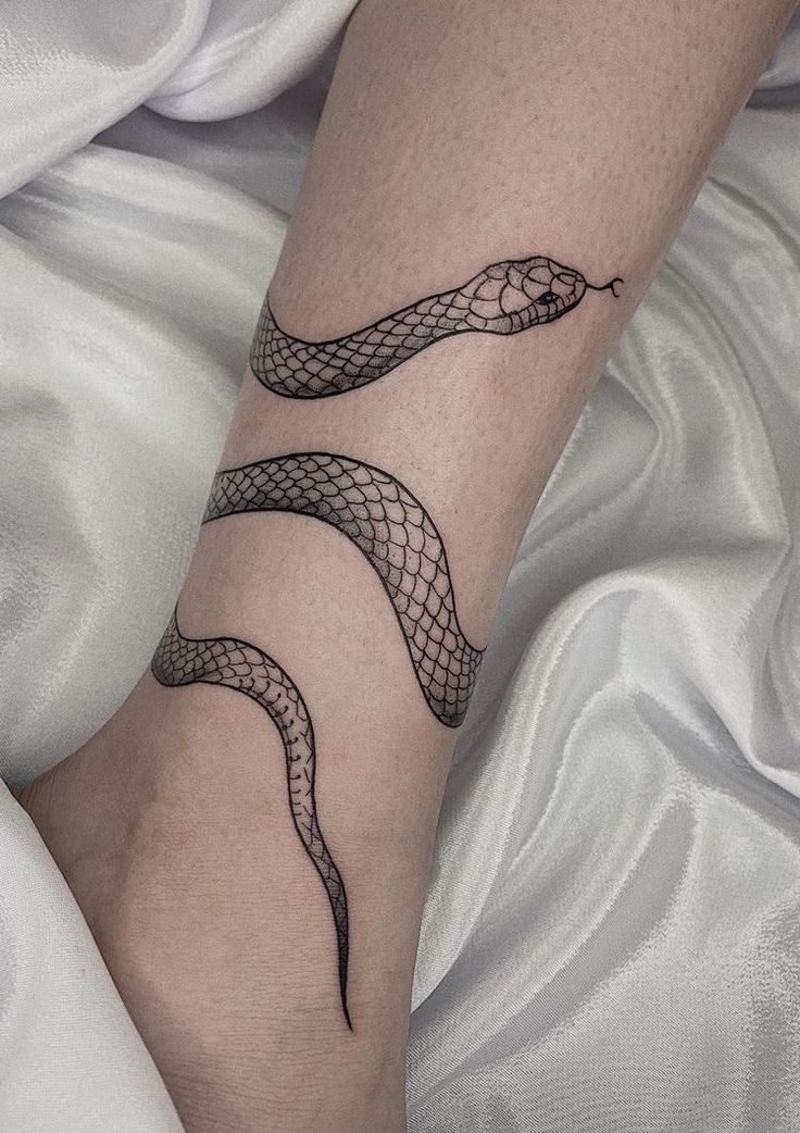 a woman's foot with a snake tattoo on it