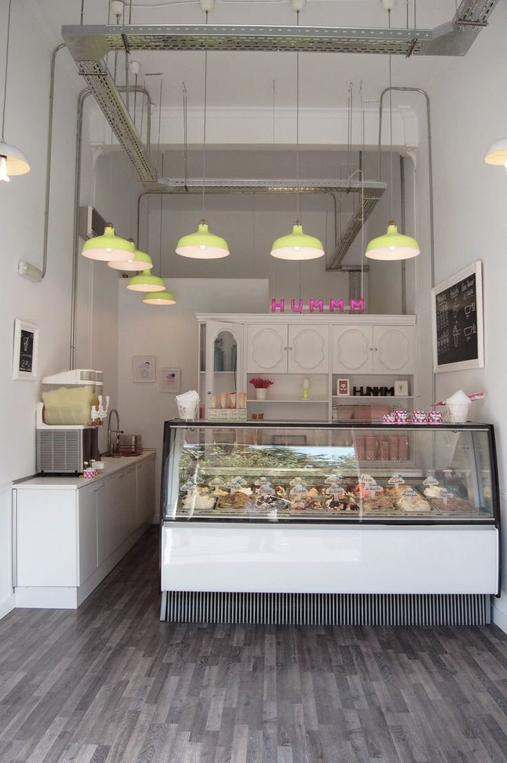 the inside of a bakery with lights hanging from the ceiling