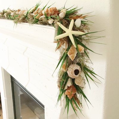 a decorated fireplace mantel with seashells and starfish