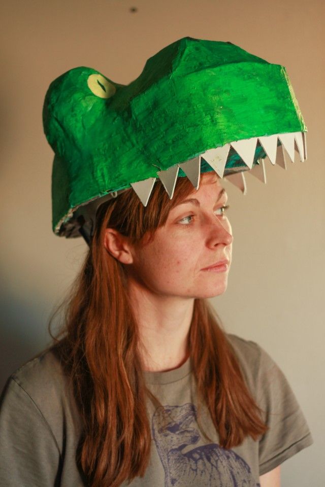 a woman wearing a green hat with large teeth